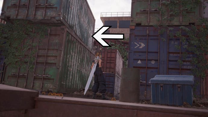 An arrow points to the left of the screen showing the exit point between the large ship containers that Cloud is standing between.