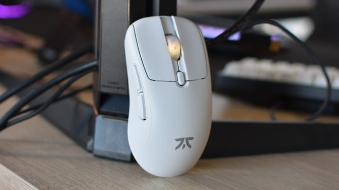 The Fnatic Bolt gaming mouse, propped up against a monitor stand.