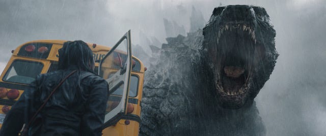 Still image featuring Godzilla towering over a bus