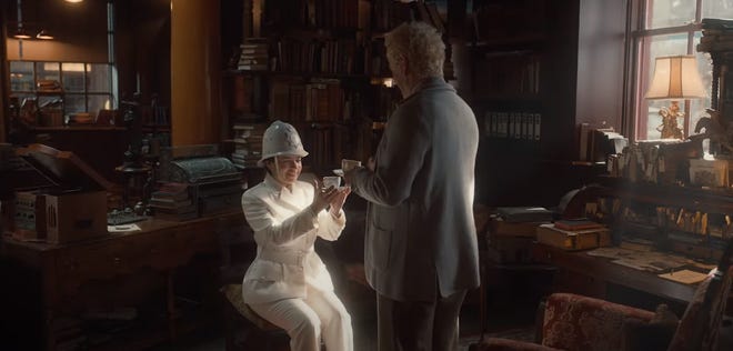 Aziraphale handing an angel a cup of tea in his bookstore