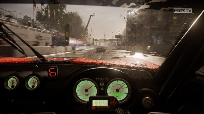 An interior view of a racing car showing a rainy race track in Grid Legends