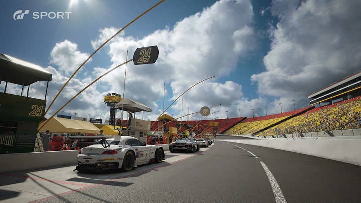 GT Sport screenshot of a number of cars in the pit area of a race track