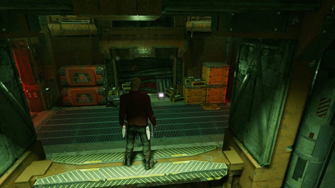 Star-Lord stood on a ledge staring down at outfit box, green lighting illuminates the room.