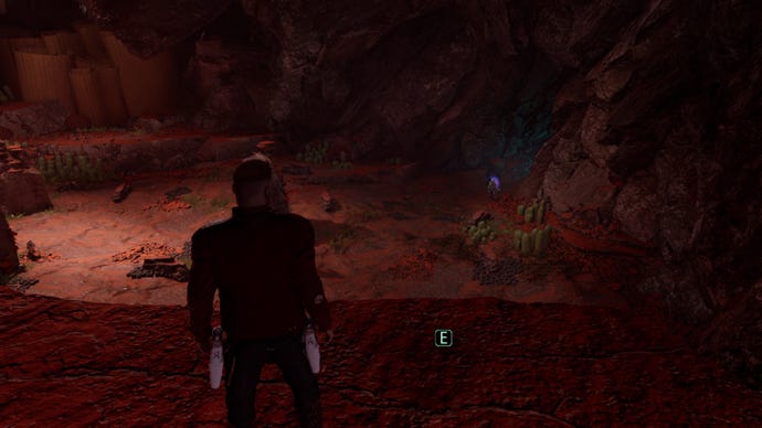 Star-Lord stands on ridge next to collectible, stares down into cave where Mantis is controlling Drax