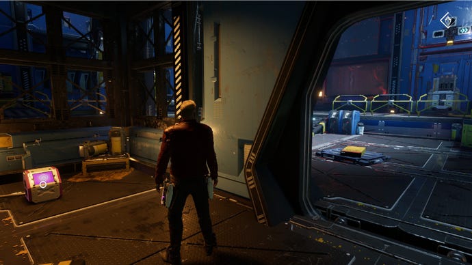 Star-Lord stood in small room with outfit box on left and doorway on the right