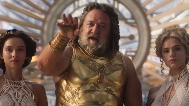 Image of Russell Crowe as Zeus, alongside two women