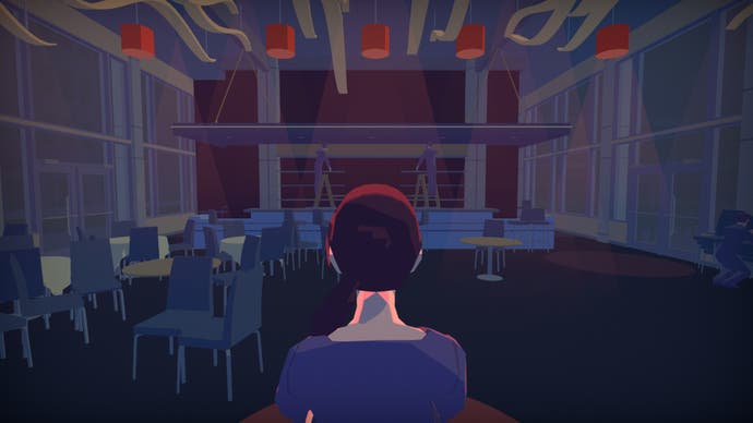 A lady sitting with her back to us in an empty auditorium, presumably having watched a performance of some kind.