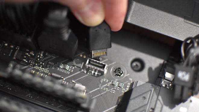 A front panel USB-C cable being plugged into its motherboard connector.