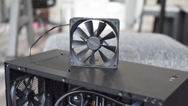 An NZXT case fan stood on top of an open PC case.