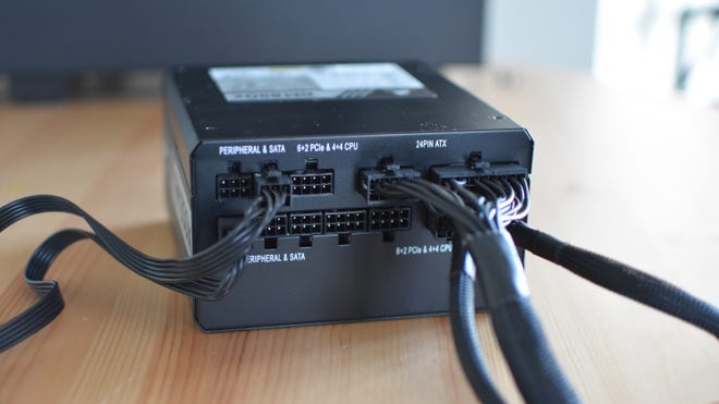 A  modular PC PSU, out of its case, with several cables connected to it.