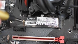 An NVMe SSD being fastened into its M.2 slot by a small screwdriver.