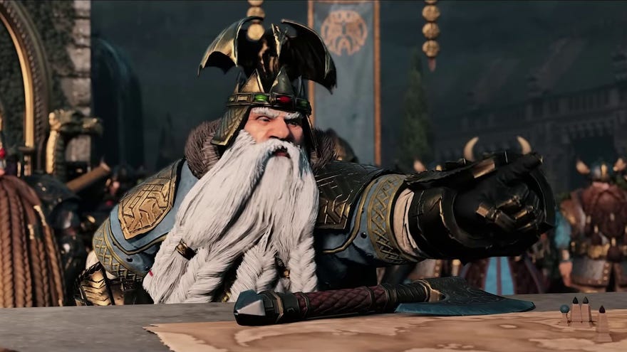 A still from the Total War Warhammer 3 Immortal Empires trailer, showing a white bearded dwarf looking very angry and pointing over a table at someone off screen