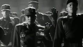 Janet Jackson and backup dancers in uniform in the Rhythm Nation music video.