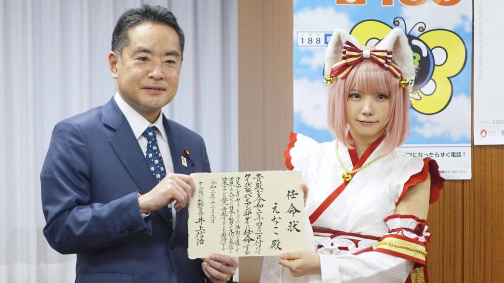 Shinji Inoue, minister in charge of Cool Japan strategy, with cosplayer Enako in December 2020. (Photo Courtesy Kyodo News)