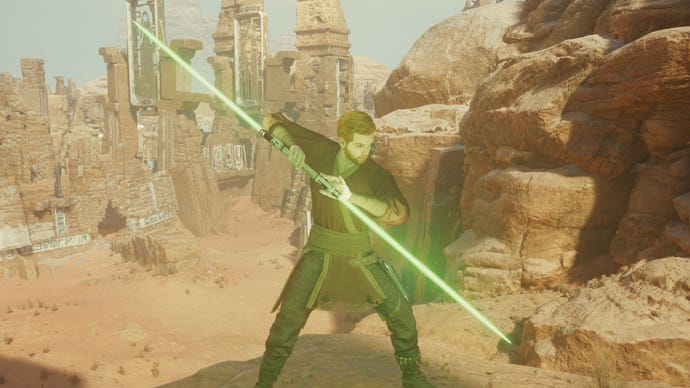 Cal holder sin grønne dobbeltbladede lyssabel klar til at forsvare sig på ørkenplaneten Jedha i Star Wars Jedi: Survivor