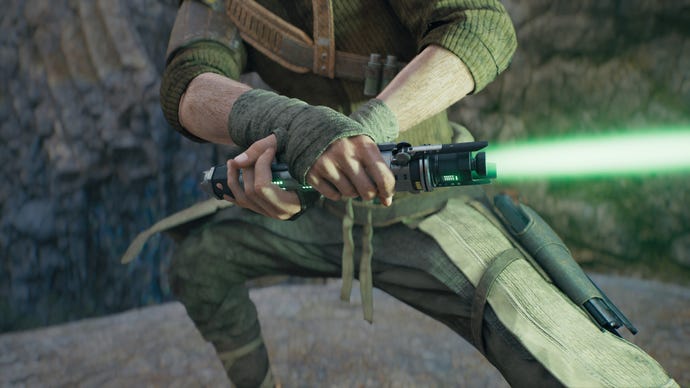 A close-up screenshot of a green-bladed lightsaber in Cal's hands in Jedi: Survivor.