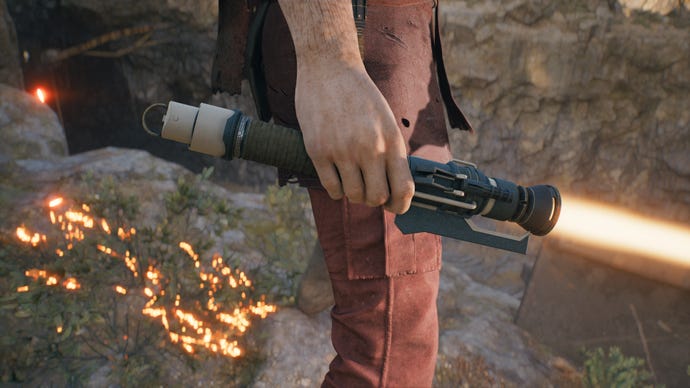 A close-up screenshot of an orange-bladed lightsaber in Cal's hand in Jedi: Survivor.