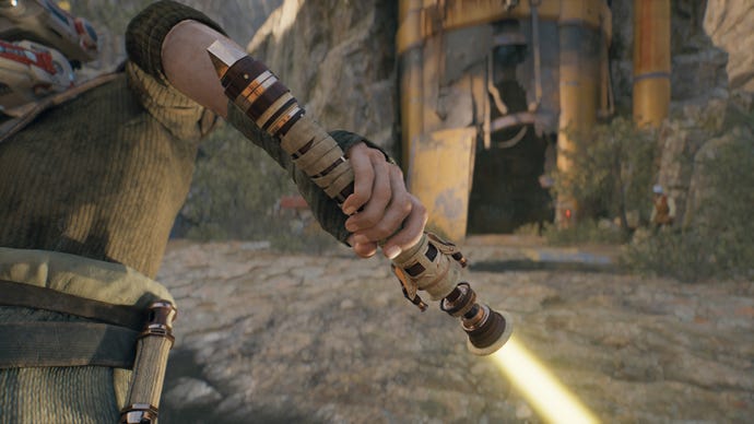 Una captura de pantalla de primer plano de un sable de luz de hoja amarilla en la mano de Cal en Jedi: Survivor.