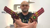 Hideki Kamiya holding Bayonetta replica guns at the PlatinumGames office