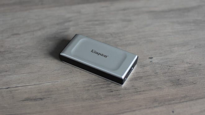The Kingston XS2000 portable SSD, without its detachable cable, on a table.