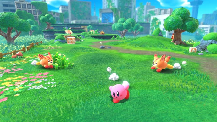 Kirby running along some grass with some dogs chasing.