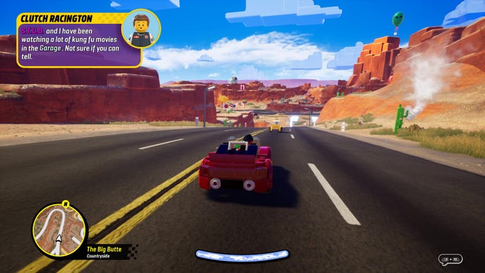 Une capture d'écran de Lego 2KDrive qui montre une voiture de course rouge flamboyant sur une route du désert.