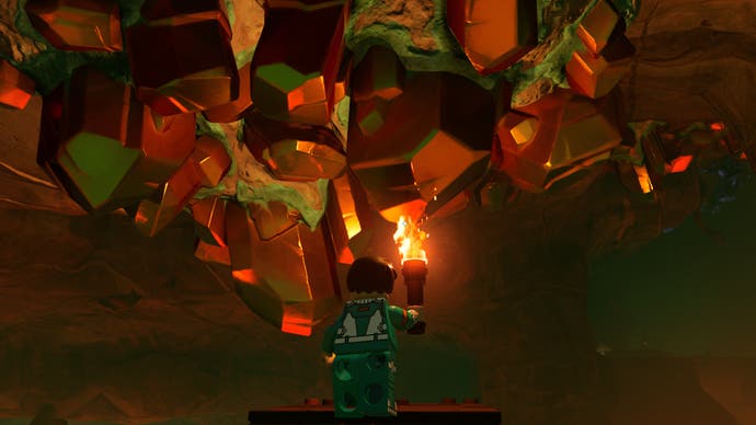 lego fortnite character facing a copper deposit in a lava cave with a flame torch
