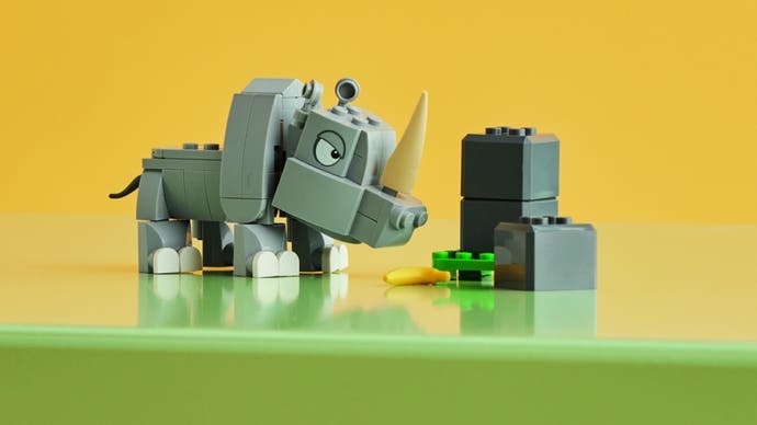 Set Rambi the Rhino dari Lego ditampilkan dengan sosok Rambi berdiri di samping tumpukan batu Lego dengan latar belakang kuning.