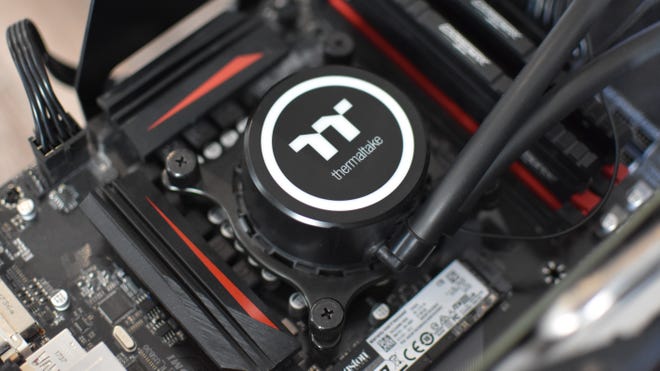 The pump of a Thermaltake liquid CPU cooler, installed on a motherboard.