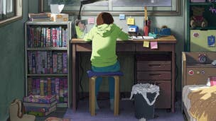 A girl in a green hoodie sat at her desk drawing manga.