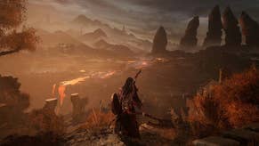 Lords of the Fallen promotional image showing a bedraggled main character looking out over a burnt orange and brown landscape witha giant five-fingered hand in the far distance jutting out from the horizon