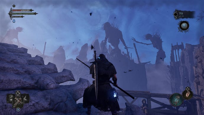 The player looks out at a blue vista filled with two enormous skeletons in Lords Of The Fallen.