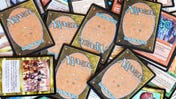 A pile of Magic: The Gathering cards, showing the front of some cards and the backs of others
