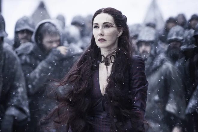 Still of Melisandre standing in the snow with soldiers behind her