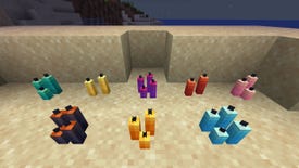 A Minecraft screenshot of an arrangement of Candles of different colours on a beach at night.