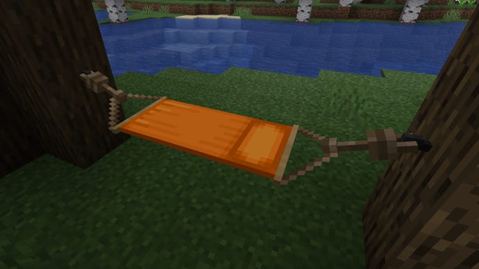 An orange hammock strung between two trees in Minecraft, made using the Comforts mod.