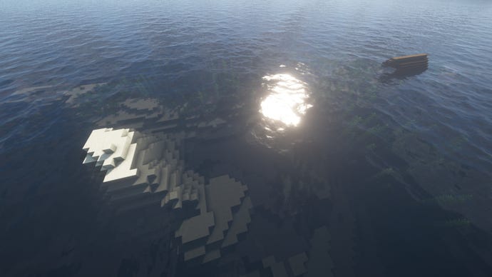 Một đại dương Minecraft, với một hòn đảo cát nhỏ ở bên trái và một con tàu đắm đang thò ra khỏi biển bên phải