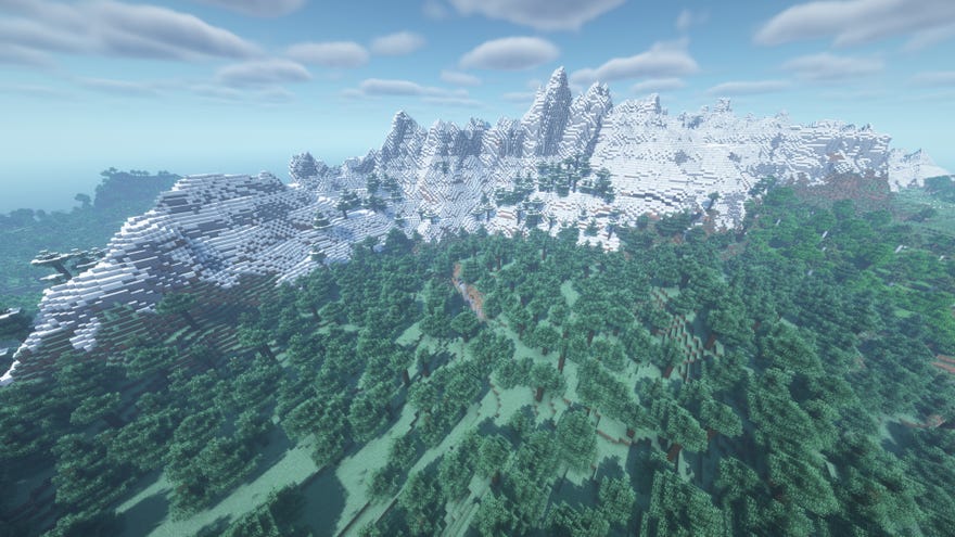 Eine massive schneebedeckte Bergkette in Minecraft, umgeben von Wald