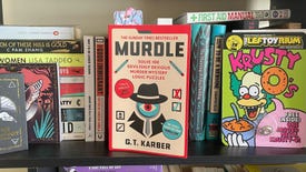 A copy of the book Murdle (volume 1) on my book shelf, next to a Krusty-O and against a variety of other books