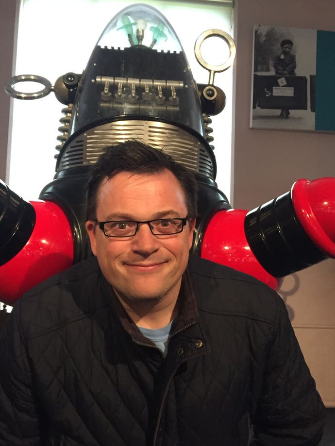 A photo portrait of Nick Roberts in front of the robot from Lost in Space.