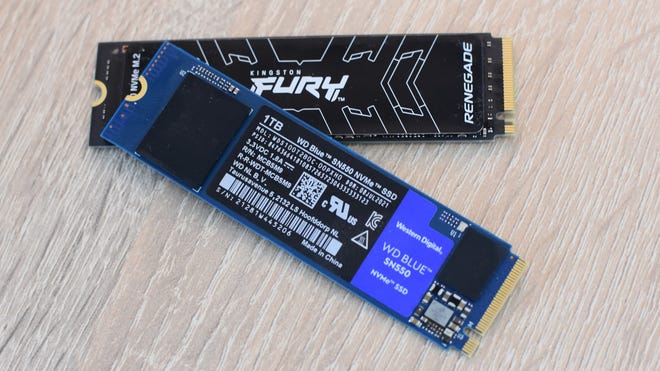 Deux SSD NVMe, le Kingston Fury Renegade et le WD Blue SN550, sur un bureau.