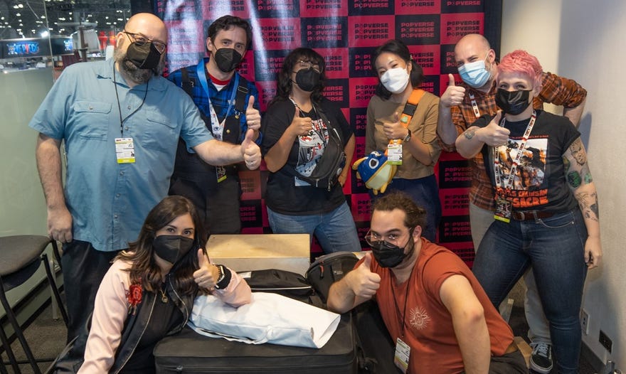 Photo featuring Povperse team in office at NYCC looking at camera with thumbs up