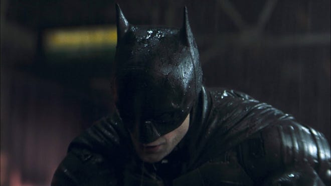 Batman looks down in the rain