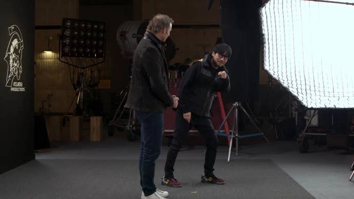 Kojima stands in a studio, dancing, to announce Physint.