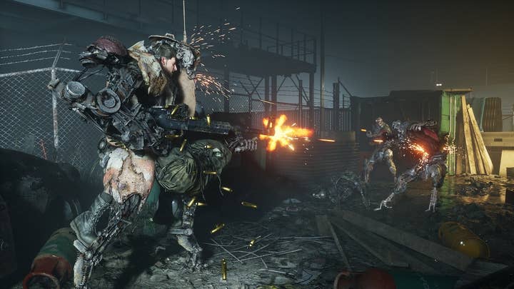 A man in a makeshift exo-suit fires a large gun at approaching robots