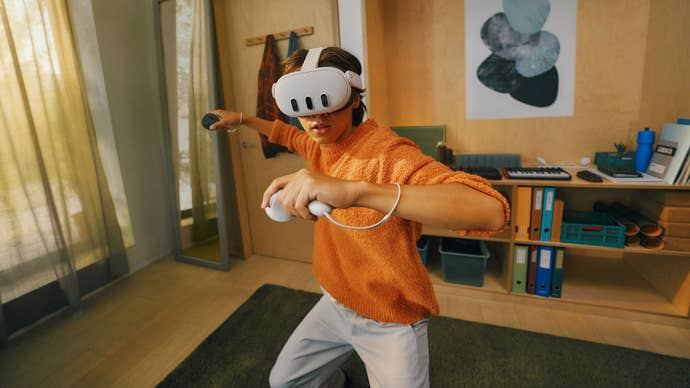 Meta Quest 3 è il primo sistema VR che non è terribilmente scomodo 4 A person in an orange top and white trousers stands in a martial arts stance with two Meta Quest 3 controllers in their hands, and a headset strapped to their face.