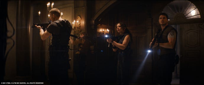 Left to right: Tom Hopper as Albert Wesker, Chad Rook as Richard Aiken, Hannah John-Kamen as Jill Valentine and Robbie Amell as Chris Redfield, exploring the mansion with guns and flashlights in the film Resident Evil: Welcome To Raccoon City