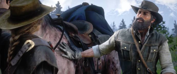 Персонаж Red Dead Redemption 2 стоит возле лошади и поглаживает ее.