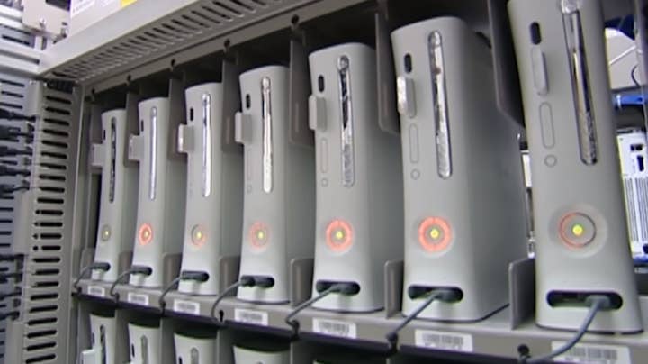 A line of seven Xbox 360 systems, each of them flashing the Red Ring of Death error lights on the front