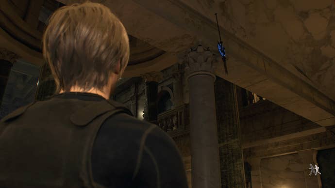 Leon Kennedy ยืนอยู่ข้างเหรียญสีฟ้าด้านหลังรูปปั้นที่ยังไม่เสร็จในห้องโถงใหญ่ใน Resident Evil 4